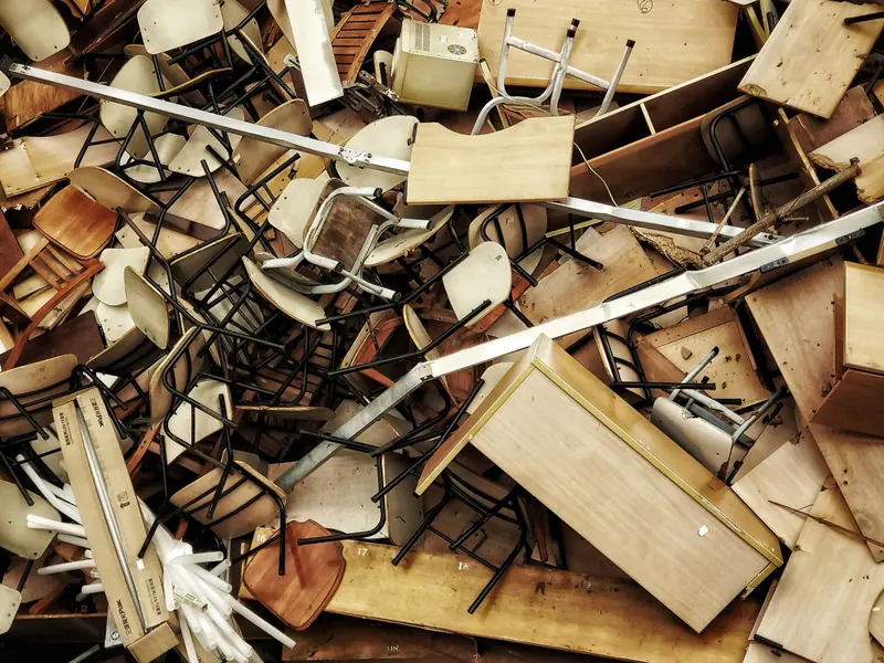 Pile of old discarded chairs, desks and furniture ready to be hauled away