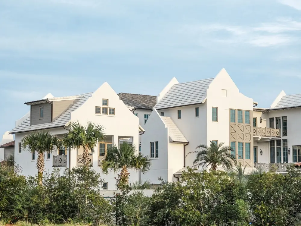 White Florida-style homes with palm trees under a blue sky